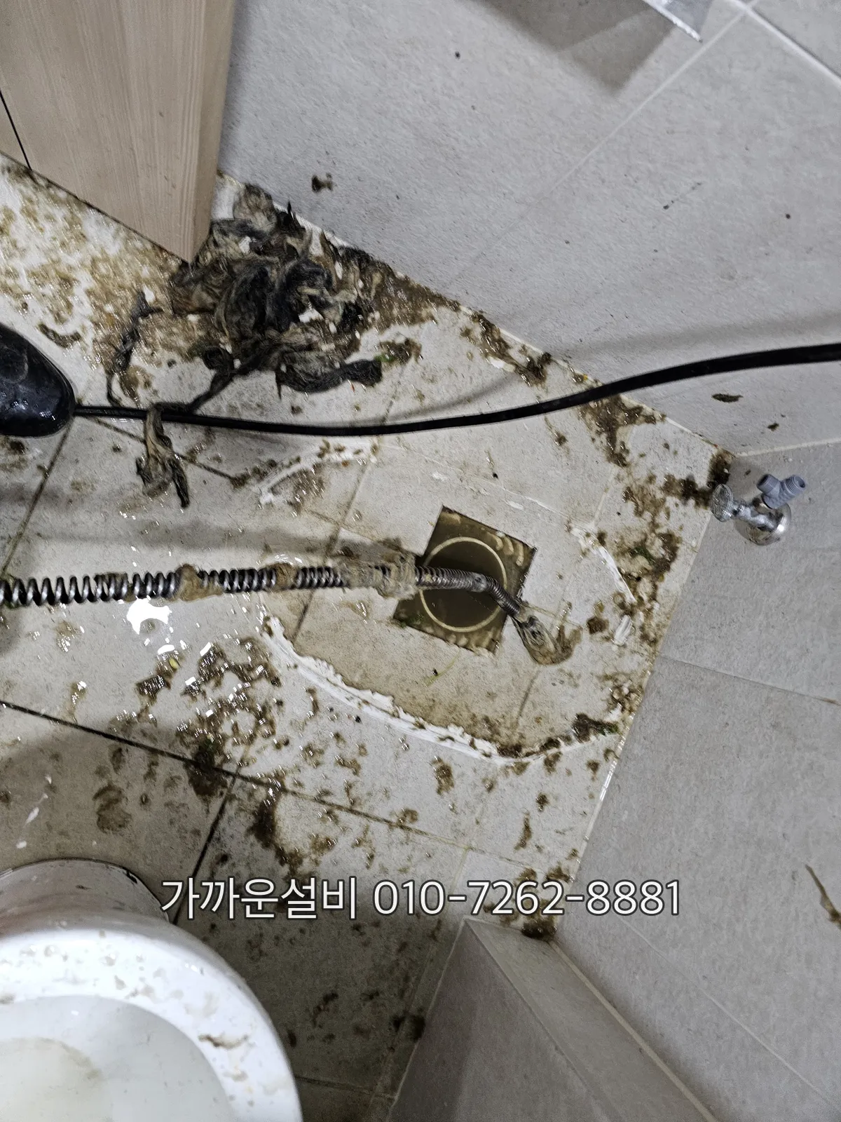 배수구 안쪽에 굳어 있는 검은 오물과 기름층 클로즈업