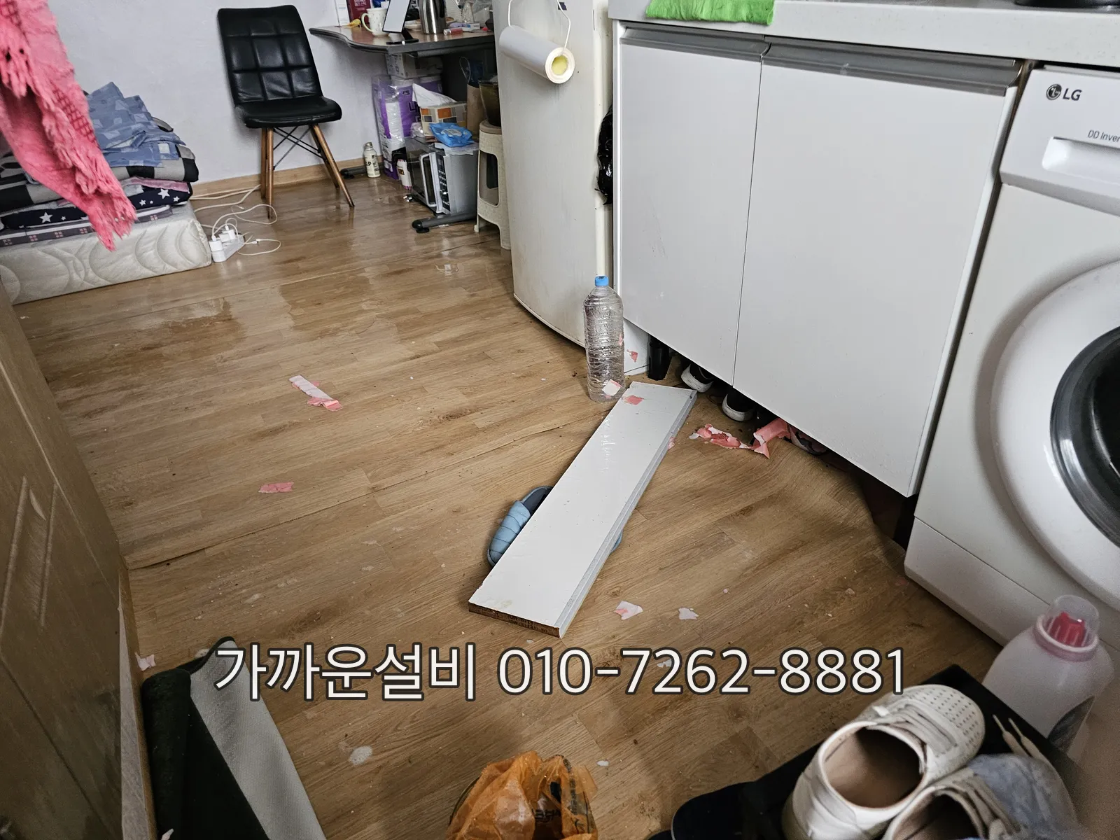 세탁실 바닥에 물이 넘친 흔적과 세탁기