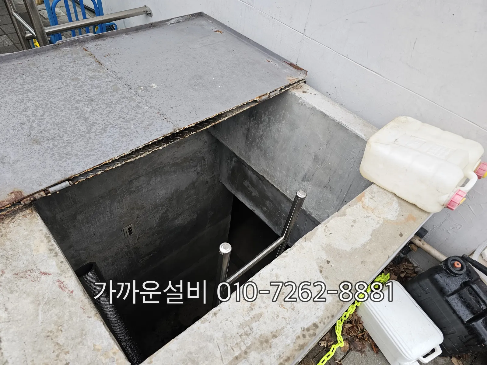 집수정 뚜껑을 열고 안에 설치된 수중펌프와 배관을 확인하는 모습